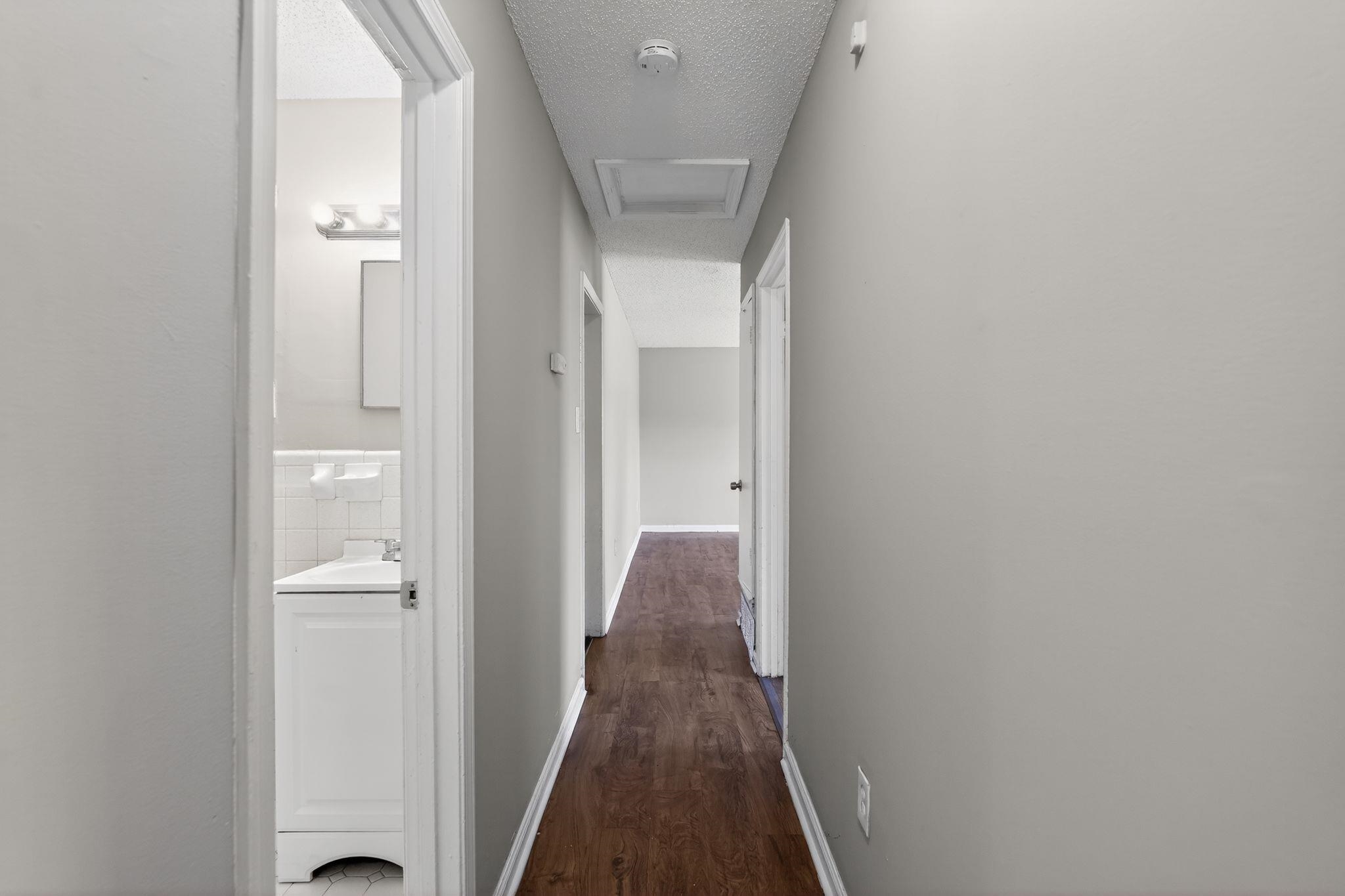 3637 Neely Road Memphis, TN 38109 - Photo 26 of 30 a view of a hallway with wooden floor and a bathroom