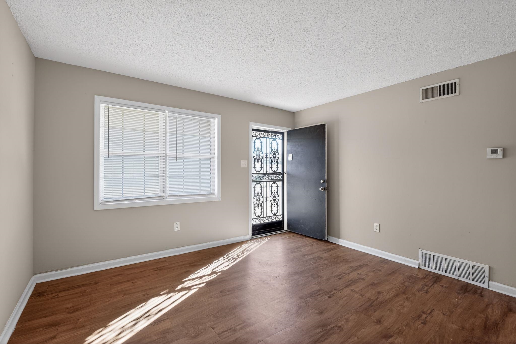3637 Neely Road Memphis, TN 38109 - Photo 5 of 30 a view of an empty room with wooden floor and a window