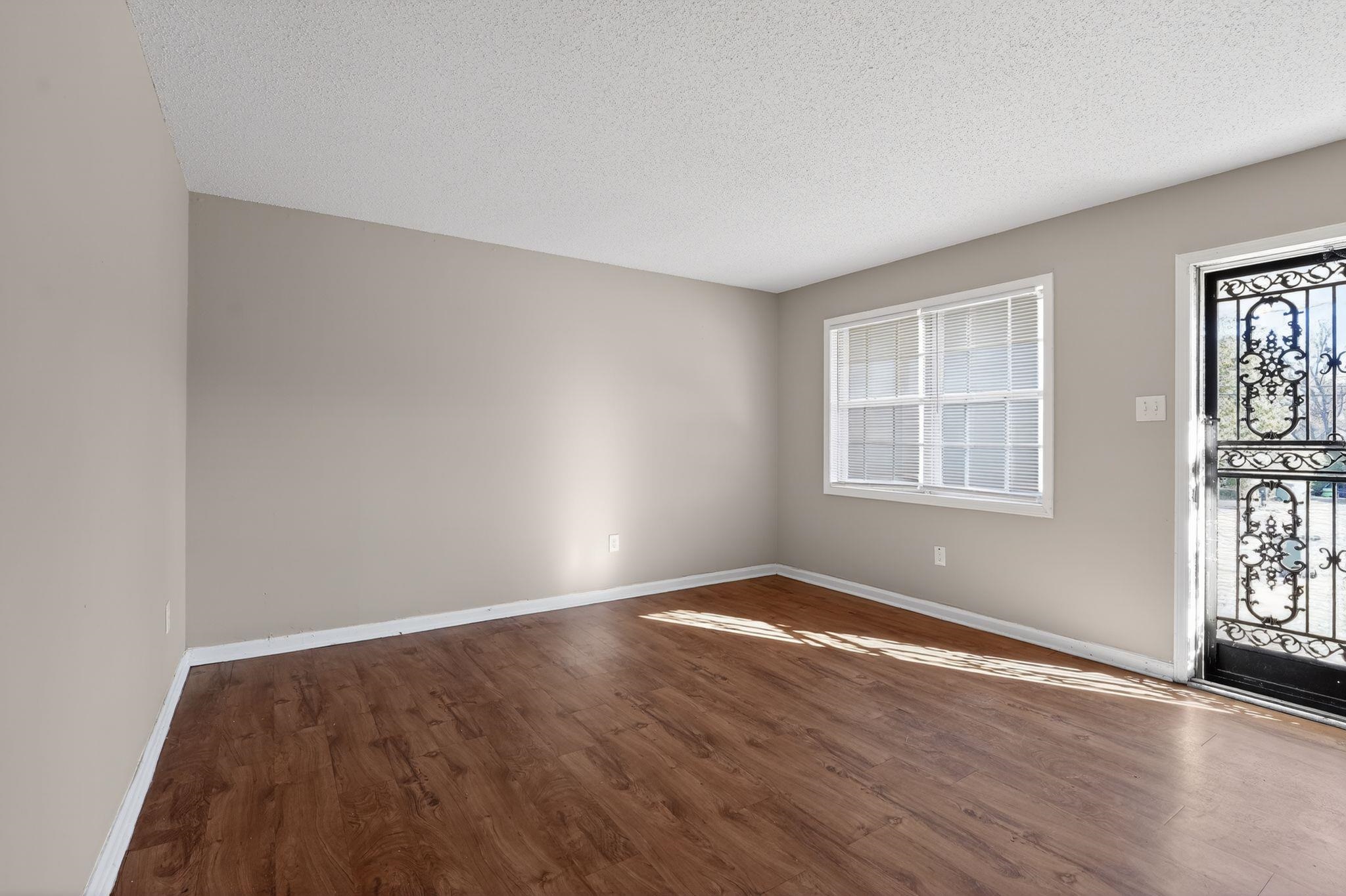 3637 Neely Road Memphis, TN 38109 - Photo 7 of 30 an empty room with wooden floor and windows