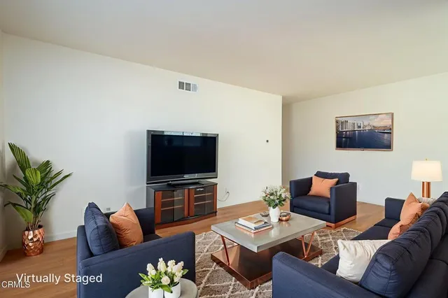 a view of a livingroom with wooden floor and a flat screen tv