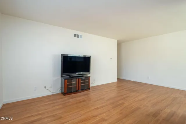 a view of a kitchen with wooden floor and windows