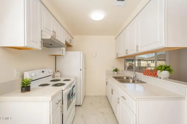 a kitchen with a stove and a white refrigerator