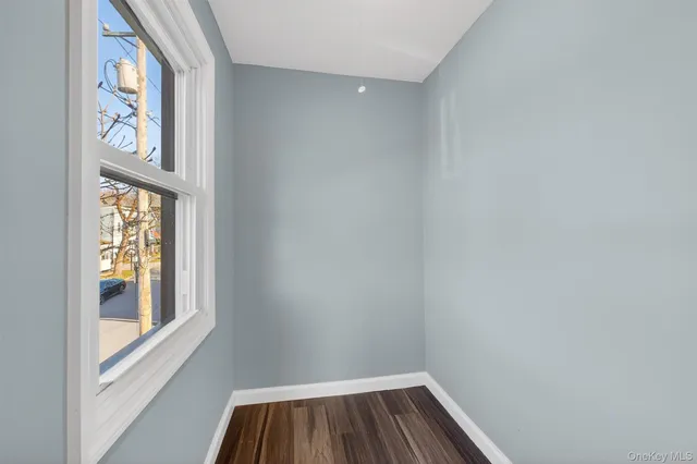 a view of room with window and wooden floor