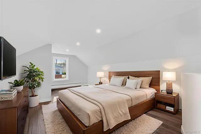 a bedroom with a large bed and a potted plant