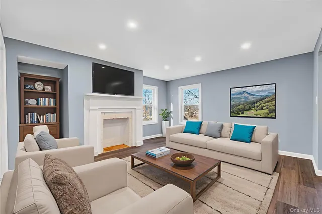 a living room with furniture a flat screen tv and a fireplace