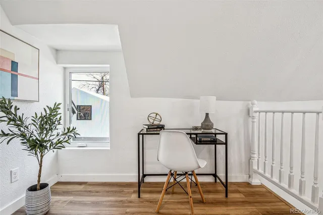 a view of a workspace with furniture and wooden floor