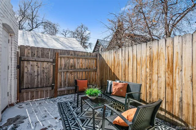 a backyard of a house with barbeque oven table and chairs
