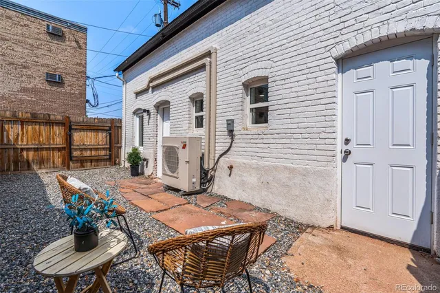 a patio with table and chairs and potted plants