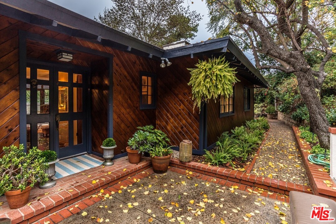 3266 Mandeville Canyon Road Los Angeles, CA 90049 - Photo 2 of 37 a view of a house with a flower garden