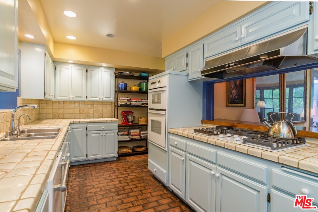3266 Mandeville Canyon Road Los Angeles, CA 90049 - Photo 13 of 37 a kitchen with stainless steel appliances granite countertop a sink stove and refrigerator