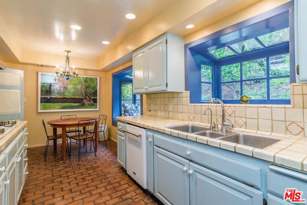 3266 Mandeville Canyon Road Los Angeles, CA 90049 - Photo 14 of 37 a kitchen with a sink and wooden cabinets