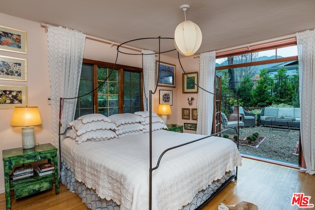 3266 Mandeville Canyon Road Los Angeles, CA 90049 - Photo 15 of 37 a bedroom with a bed mirror and window