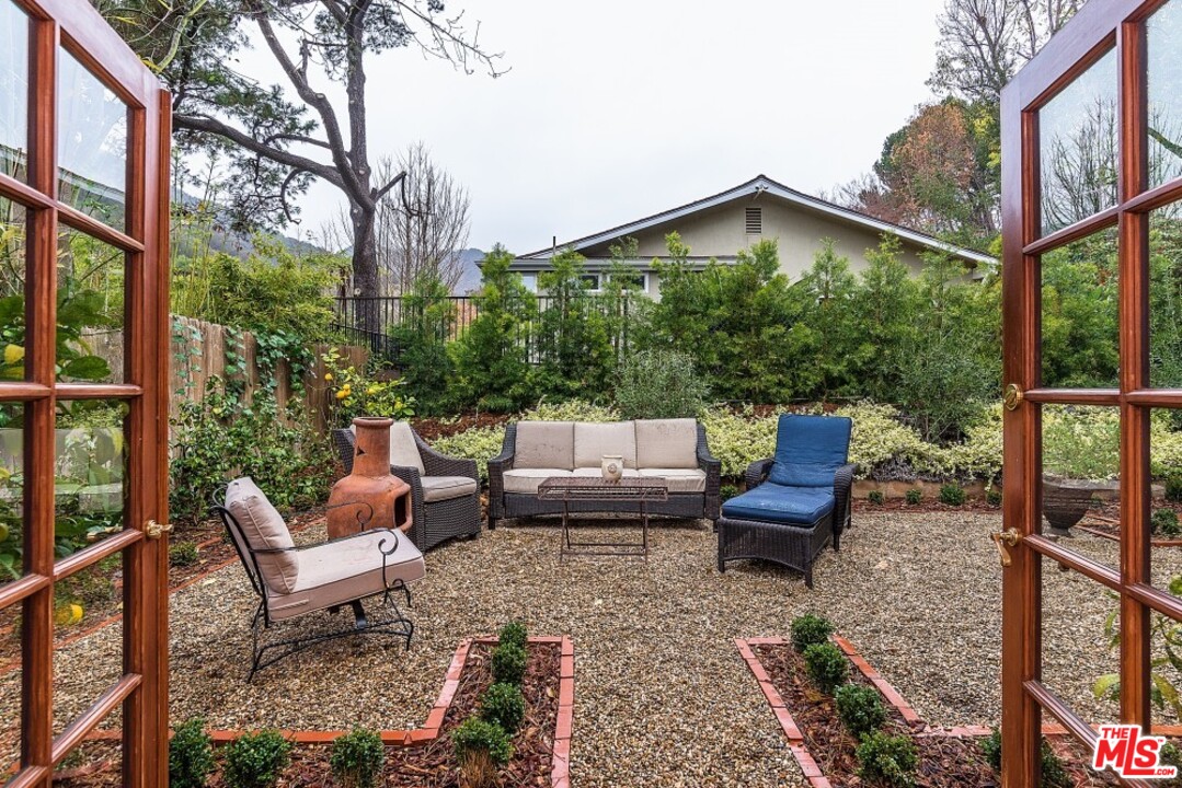 3266 Mandeville Canyon Road Los Angeles, CA 90049 - Photo 16 of 37 a view of a chairs and table in the back yard of the house