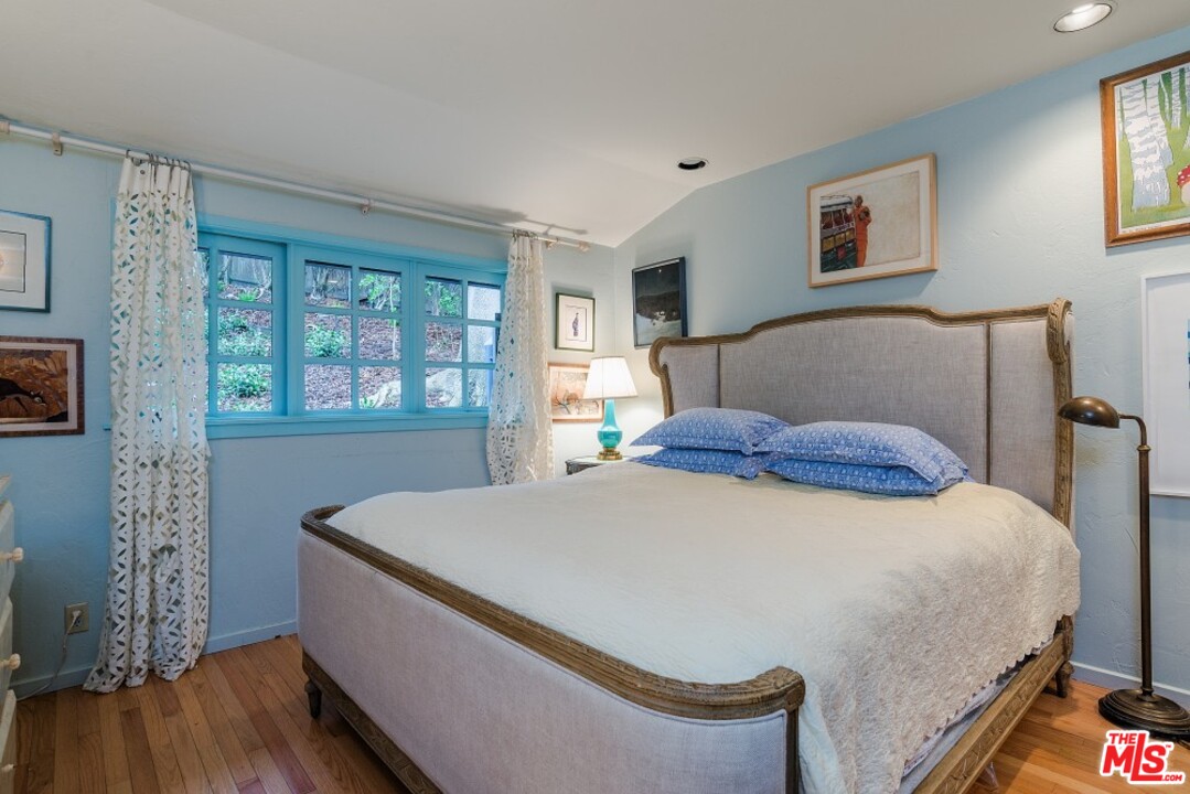 3266 Mandeville Canyon Road Los Angeles, CA 90049 - Photo 20 of 37 a bedroom with a bed and wooden floor