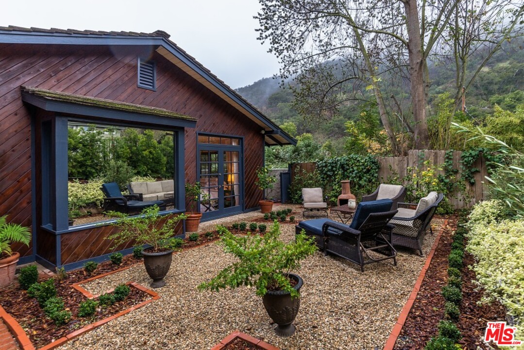 3266 Mandeville Canyon Road Los Angeles, CA 90049 - Photo 24 of 37 a view of a house with backyard sitting area and garden