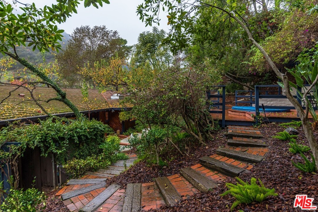 3266 Mandeville Canyon Road Los Angeles, CA 90049 - Photo 27 of 37 a backyard of a house with lots of green space