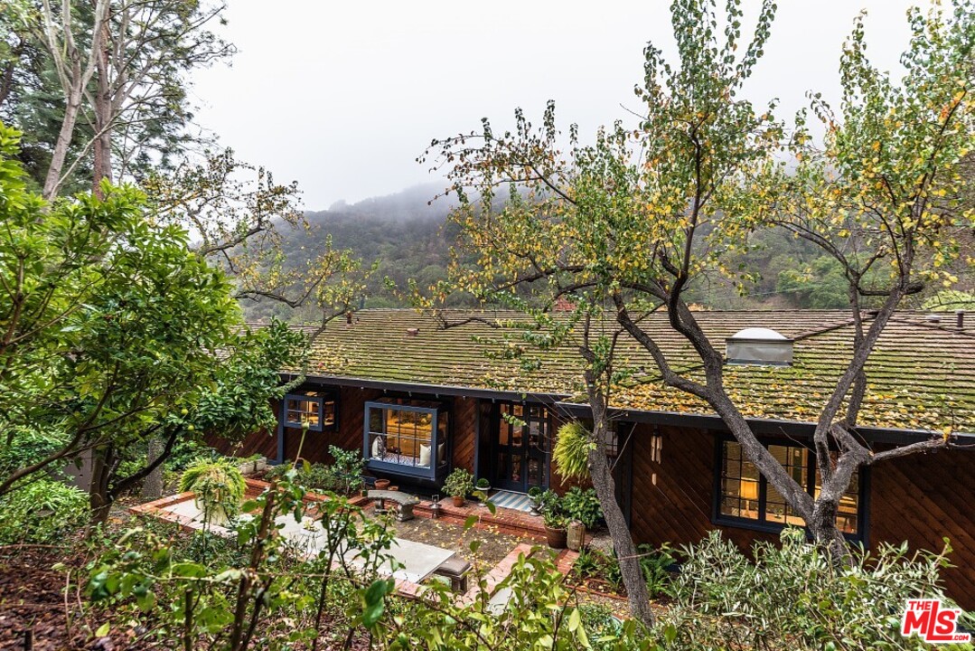 3266 Mandeville Canyon Road Los Angeles, CA 90049 - Photo 32 of 37 a view of a backyard with large trees