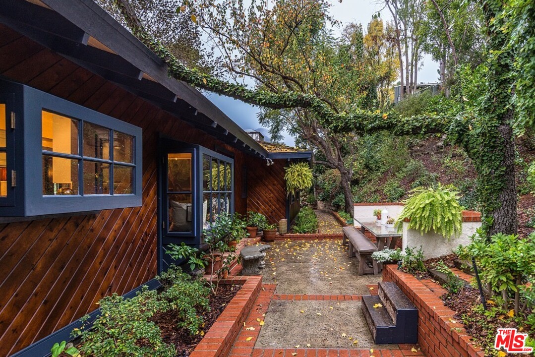 3266 Mandeville Canyon Road Los Angeles, CA 90049 - Photo 35 of 37 a view of an house with backyard space and garden
