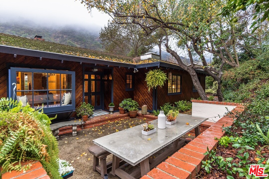 3266 Mandeville Canyon Road Los Angeles, CA 90049 - Photo 37 of 37 a view of an house with backyard porch and furniture