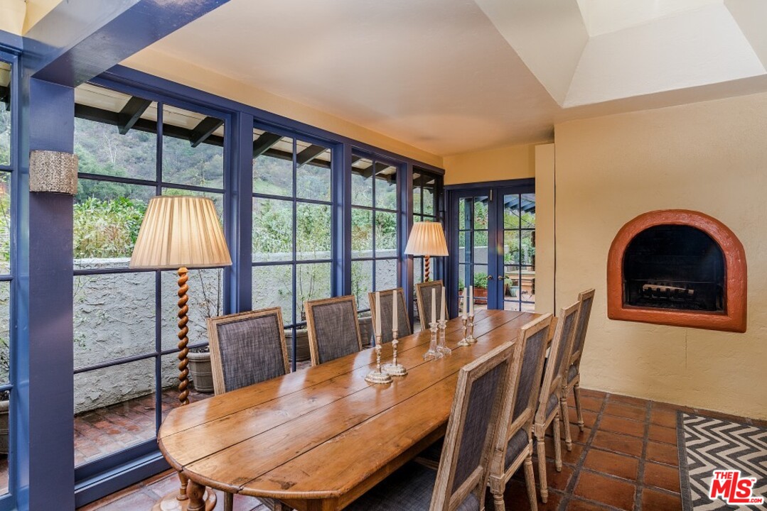 3266 Mandeville Canyon Road Los Angeles, CA 90049 - Photo 8 of 37 a dining room with furniture a chandelier and wooden floor