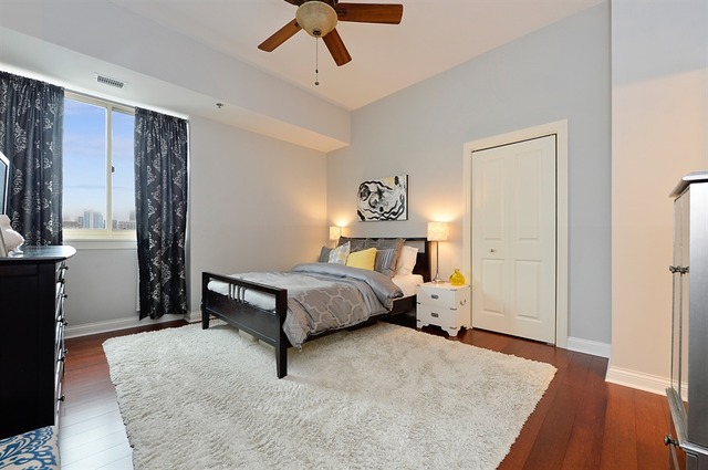 230 West Division Street, Unit 1005 Chicago, IL 60610 - Photo 7 of 15 a bedroom with a large bed and a chandelier