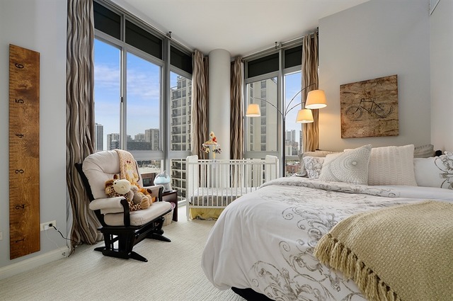 230 West Division Street, Unit 1005 Chicago, IL 60610 - Photo 9 of 15 a bedroom with bed and glass windows