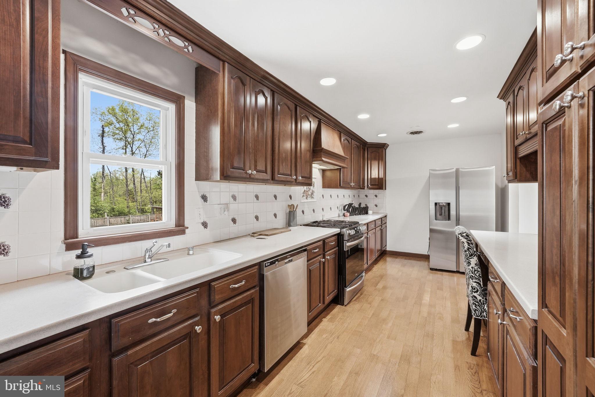 9609 Norfolk Street Manassas, VA 20109 - Photo 24 of 37 a kitchen with stainless steel appliances granite countertop sink stove refrigerator and cabinets