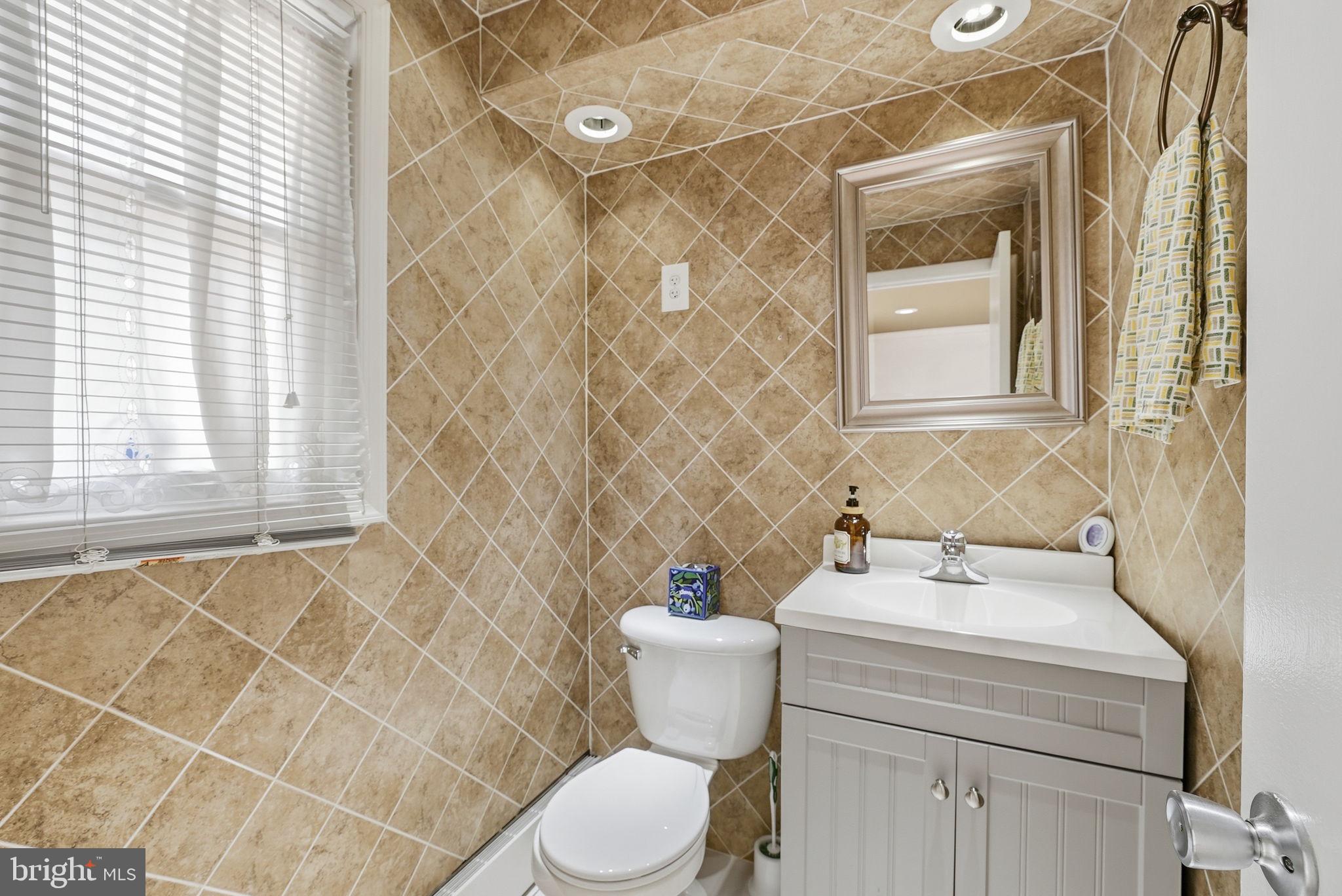 9609 Norfolk Street Manassas, VA 20109 - Photo 10 of 37 a bathroom with a sink mirror and a toilet