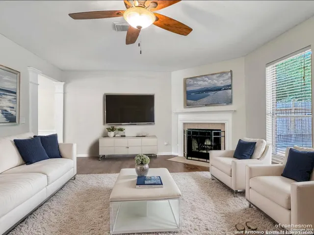 a living room with furniture a flat screen tv and a fireplace