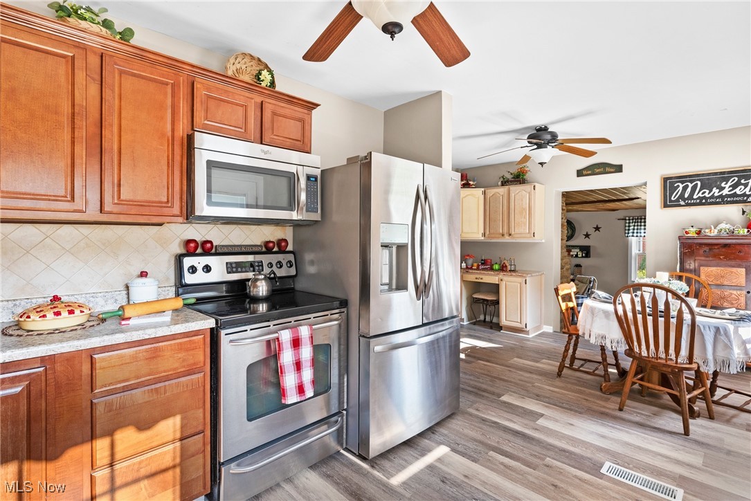 540 Park Road Painesville, OH 44077 - Photo 14 of 34 Kitchen featuring ceiling fan, stainless steel appliances, light wood-style flooring, light countertops, and backsplash