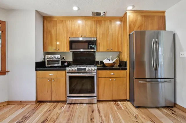 a kitchen with stainless steel appliances a refrigerator stove and microwave