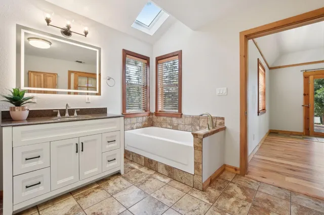 a spacious bathroom with a granite countertop tub sink and mirror