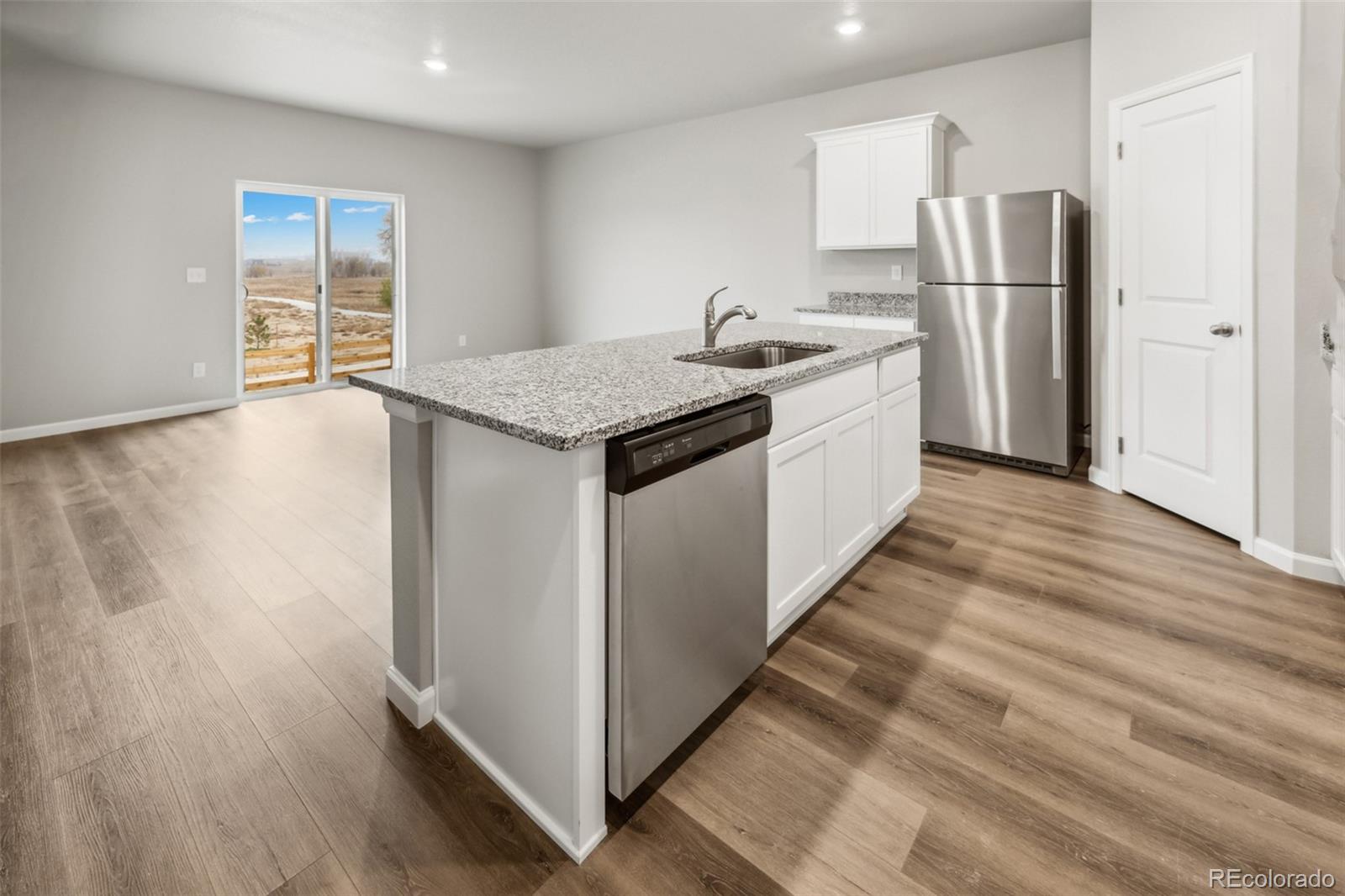 2220 Christina Street Fort Lupton, CO 80621 - Photo 4 of 42 a kitchen with stainless steel appliances granite countertop a refrigerator and a sink