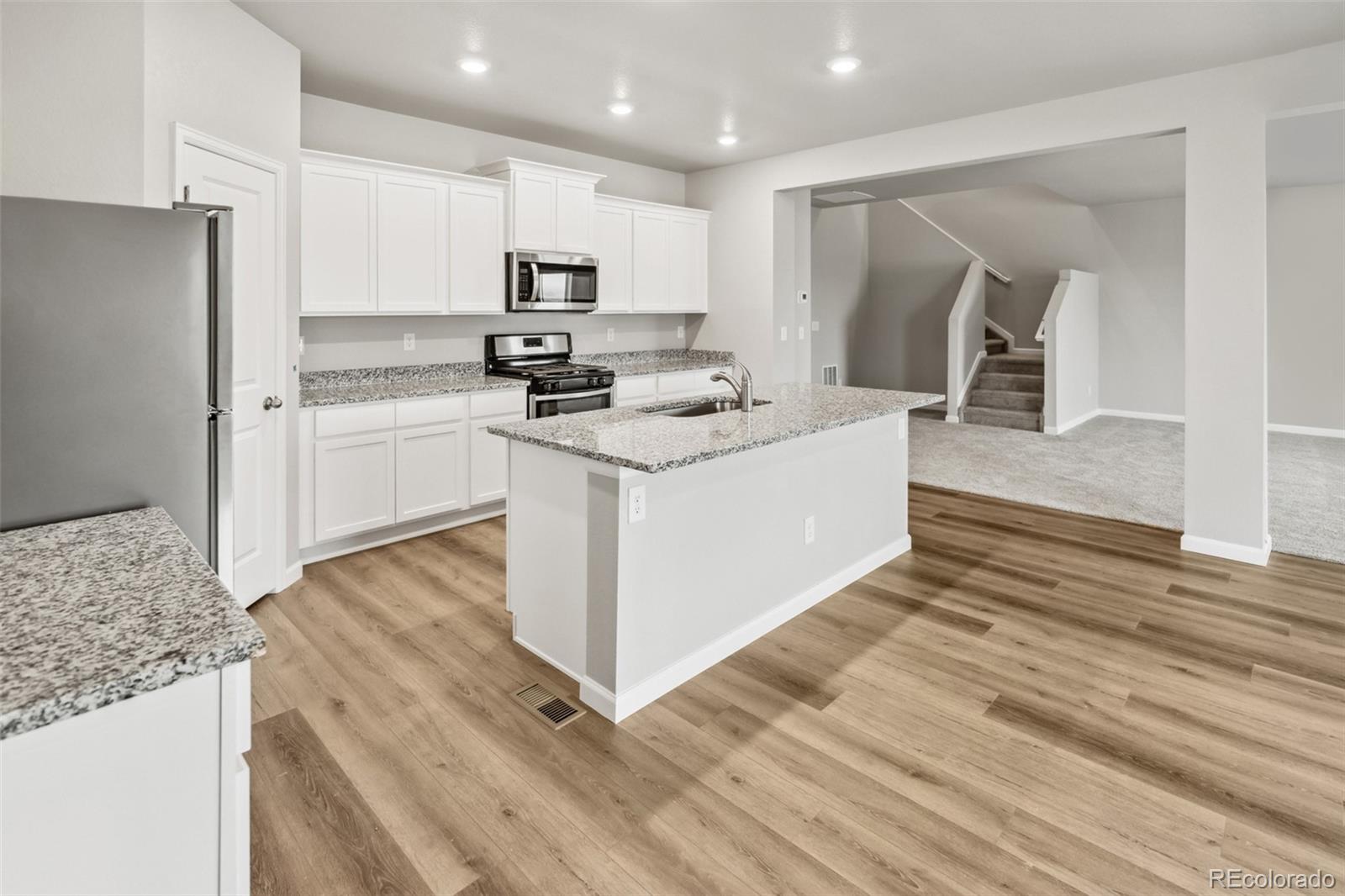 2220 Christina Street Fort Lupton, CO 80621 - Photo 5 of 42 a kitchen with a sink stove and refrigerator