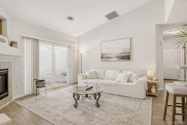 a living room with furniture a fireplace and a table