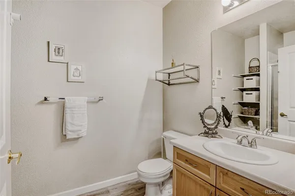 a bathroom with a granite countertop sink toilet and mirror