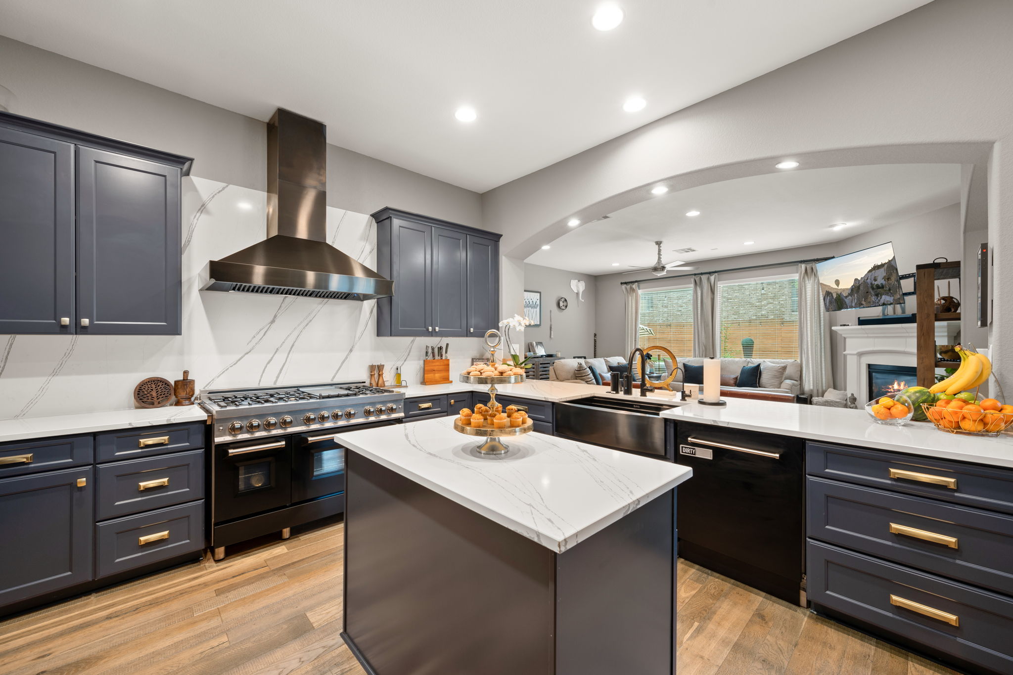 12109 Montclair Bend Austin, TX 78732 - Photo 11 of 39 Kitchen featuring dark blue cabinetry with gold-tone hardware, white countertops, and a white backsplash with gray veining