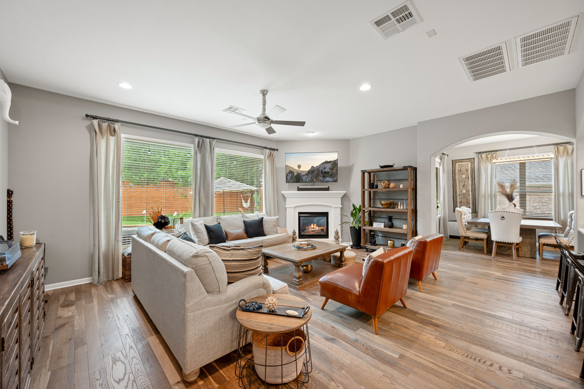 12109 Montclair Bend Austin, TX 78732 - Photo 14 of 39 Open-concept living area featuring wood-finish flooring, a fireplace with a mantel, recessed lighting, and a ceiling fan