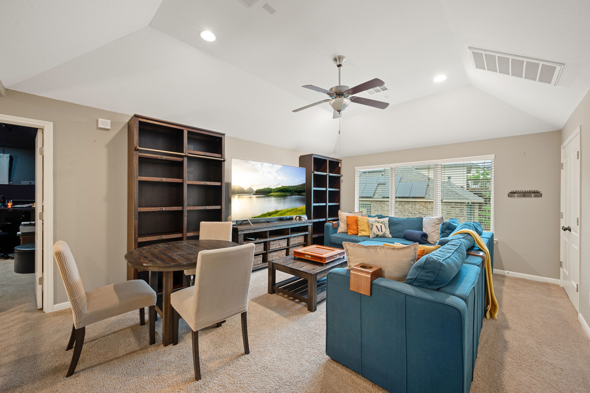 12109 Montclair Bend Austin, TX 78732 - Photo 22 of 39 Vaulted ceiling living area featuring recessed lighting, a ceiling fan, a built-in bookcase, and a wall of windows