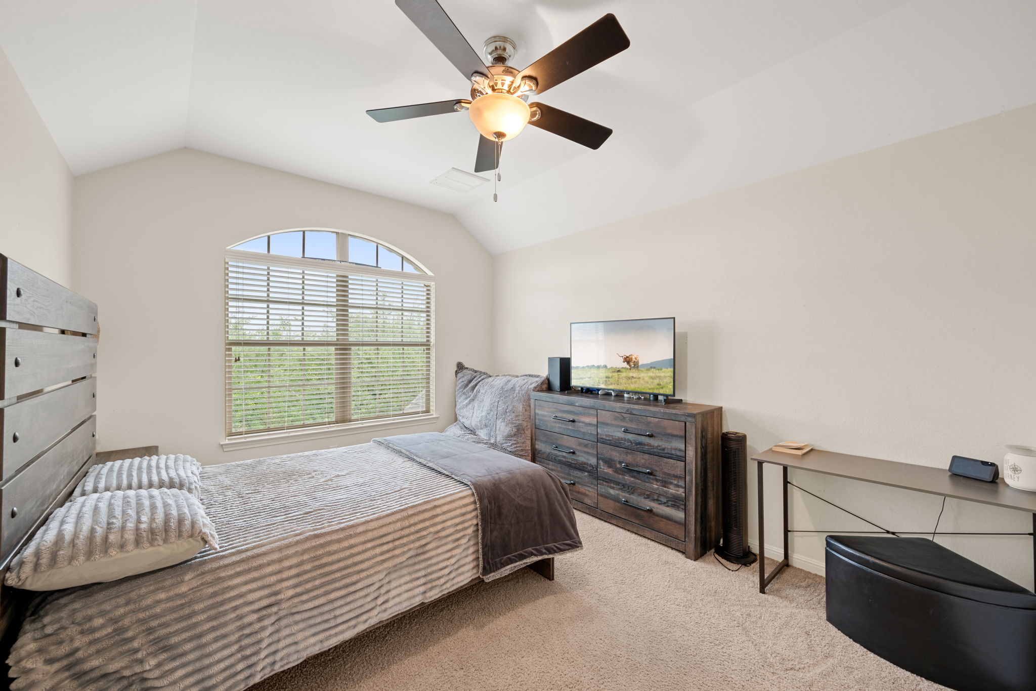 12109 Montclair Bend Austin, TX 78732 - Photo 24 of 39 Vaulted ceiling room featuring a large arched window with blinds, a ceiling fan with light fixture, and neutral carpeting