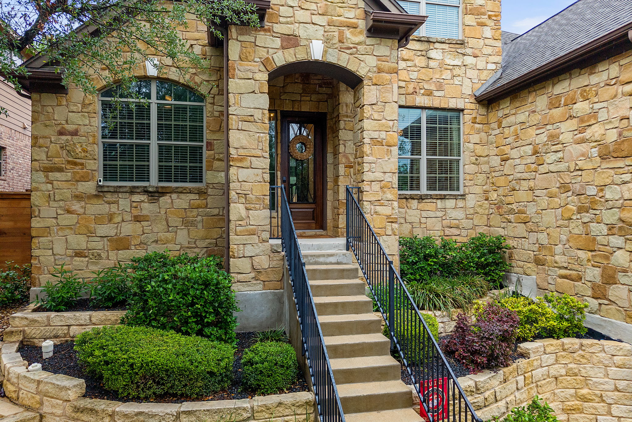 12109 Montclair Bend Austin, TX 78732 - Photo 3 of 39 Stone-clad exterior featuring a prominent arched entry