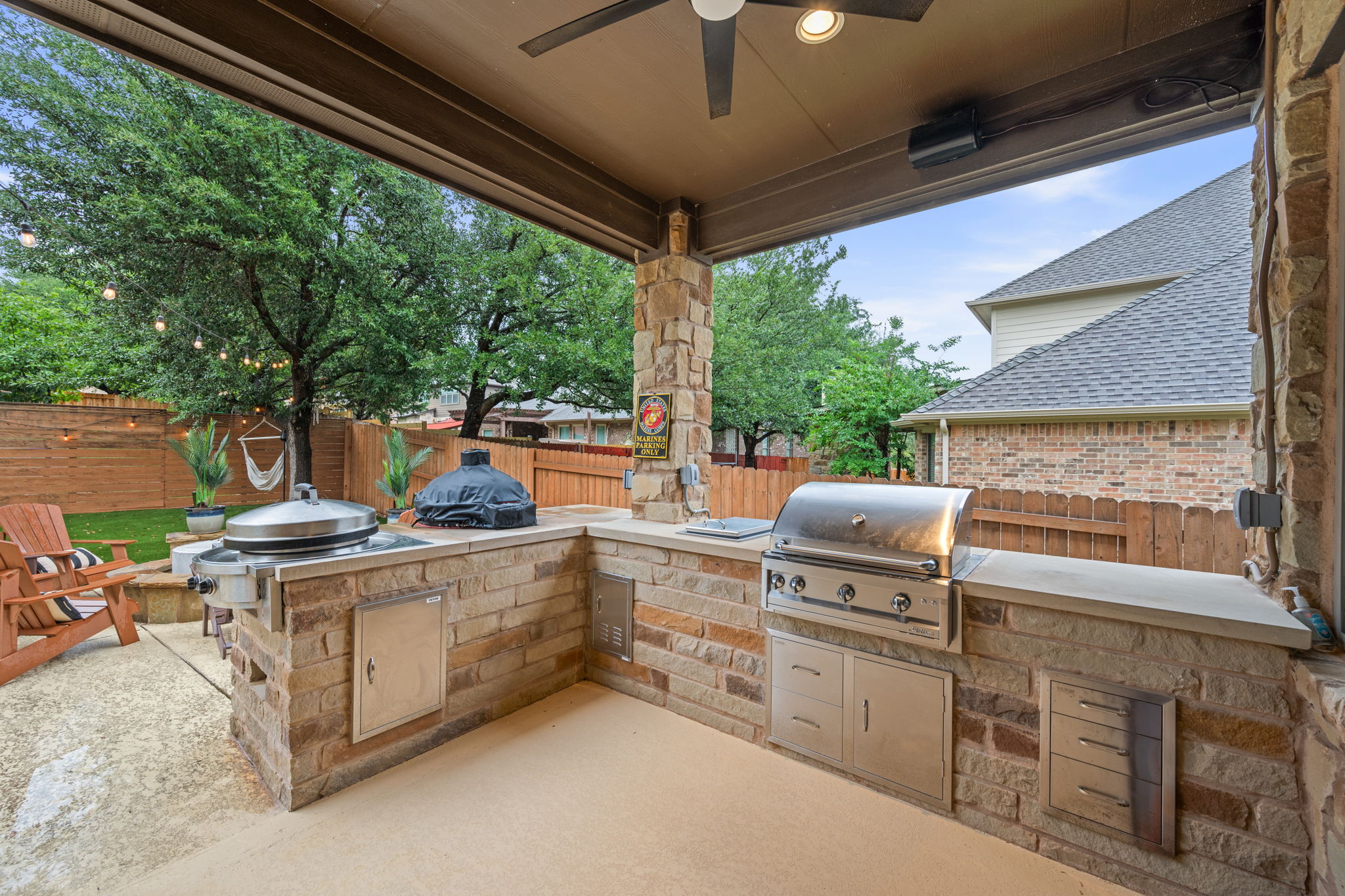 12109 Montclair Bend Austin, TX 78732 - Photo 31 of 39 Covered patio featuring an outdoor kitchen with built-in stainless steel grill, stone veneer base, and integrated storage