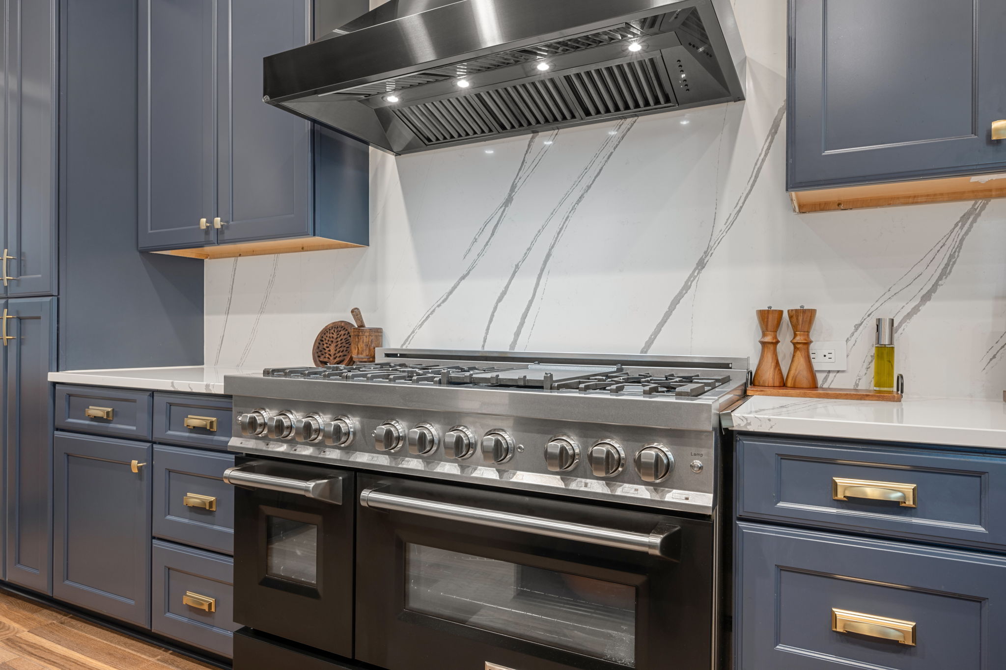 12109 Montclair Bend Austin, TX 78732 - Photo 10 of 39 Stainless steel professional-grade range and hood paired with a full-height white backsplash featuring grey veining