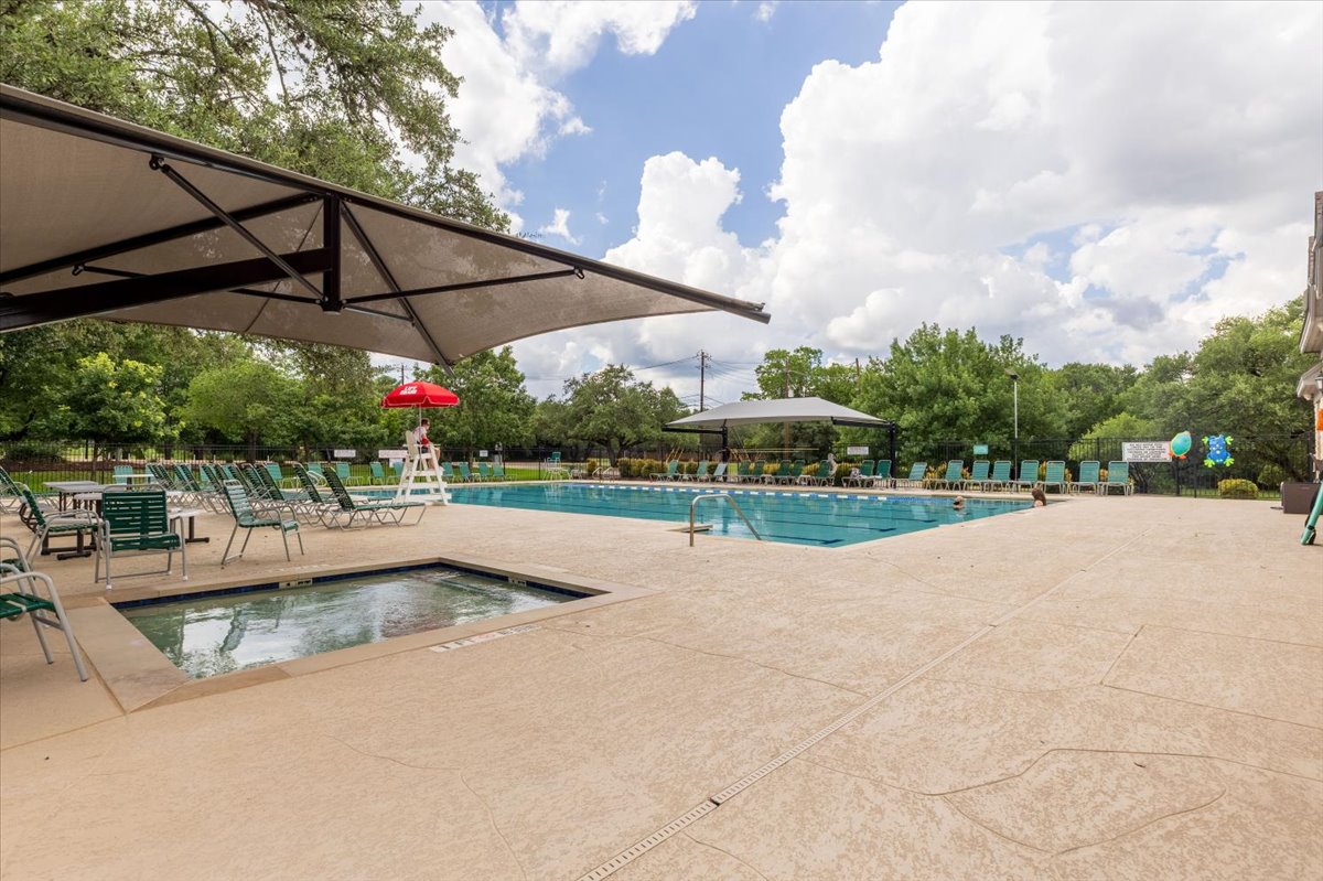 7136 Ridge Oak Road Austin, TX 78749 - Photo 22 of 28 An inviting outdoor community pool and spa await with ample seating and shaded areas for relaxation.