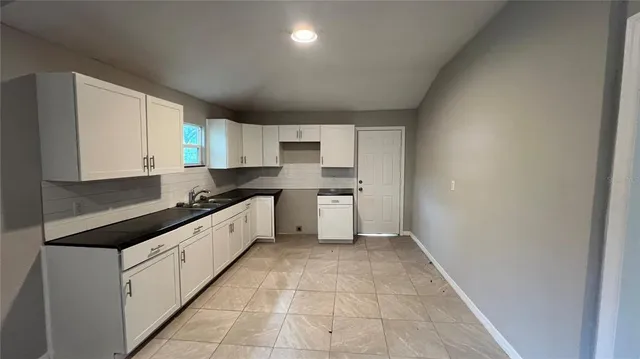a kitchen with a sink cabinets and a window