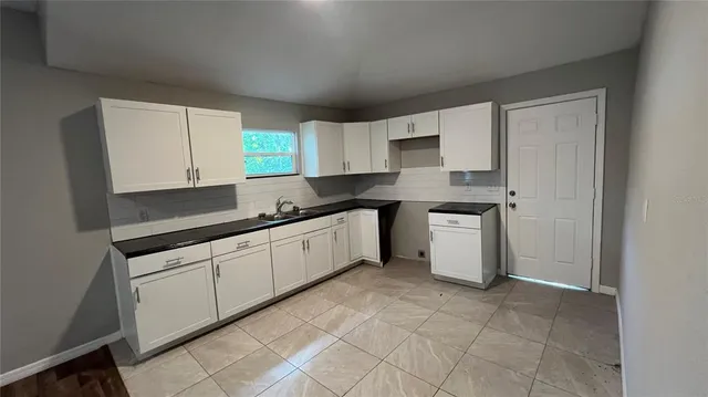 a kitchen with a sink cabinets and window