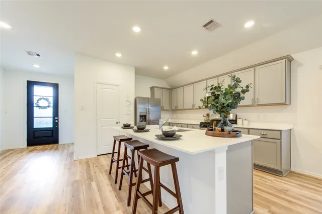 a kitchen with stainless steel appliances kitchen island granite countertop a stove a sink and a refrigerator