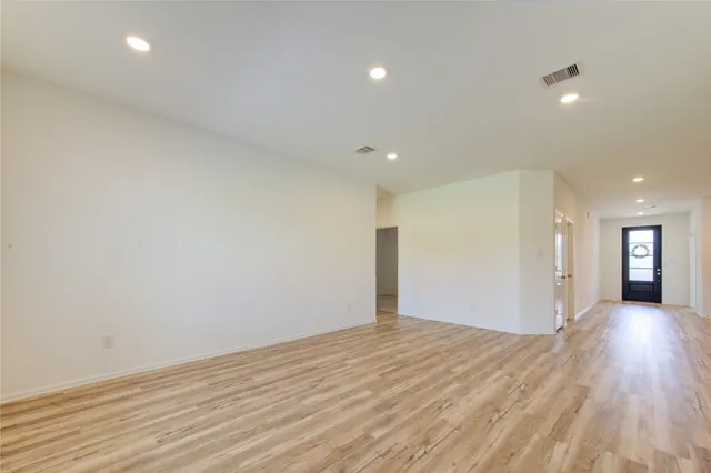 a view of a big room with wooden floor and windows