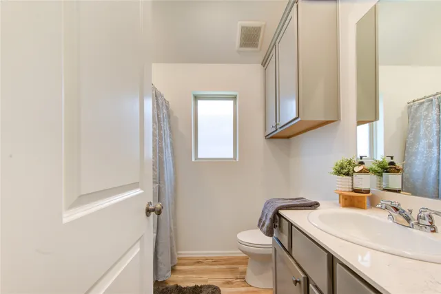 a bathroom with a sink vanity mirror and toilet