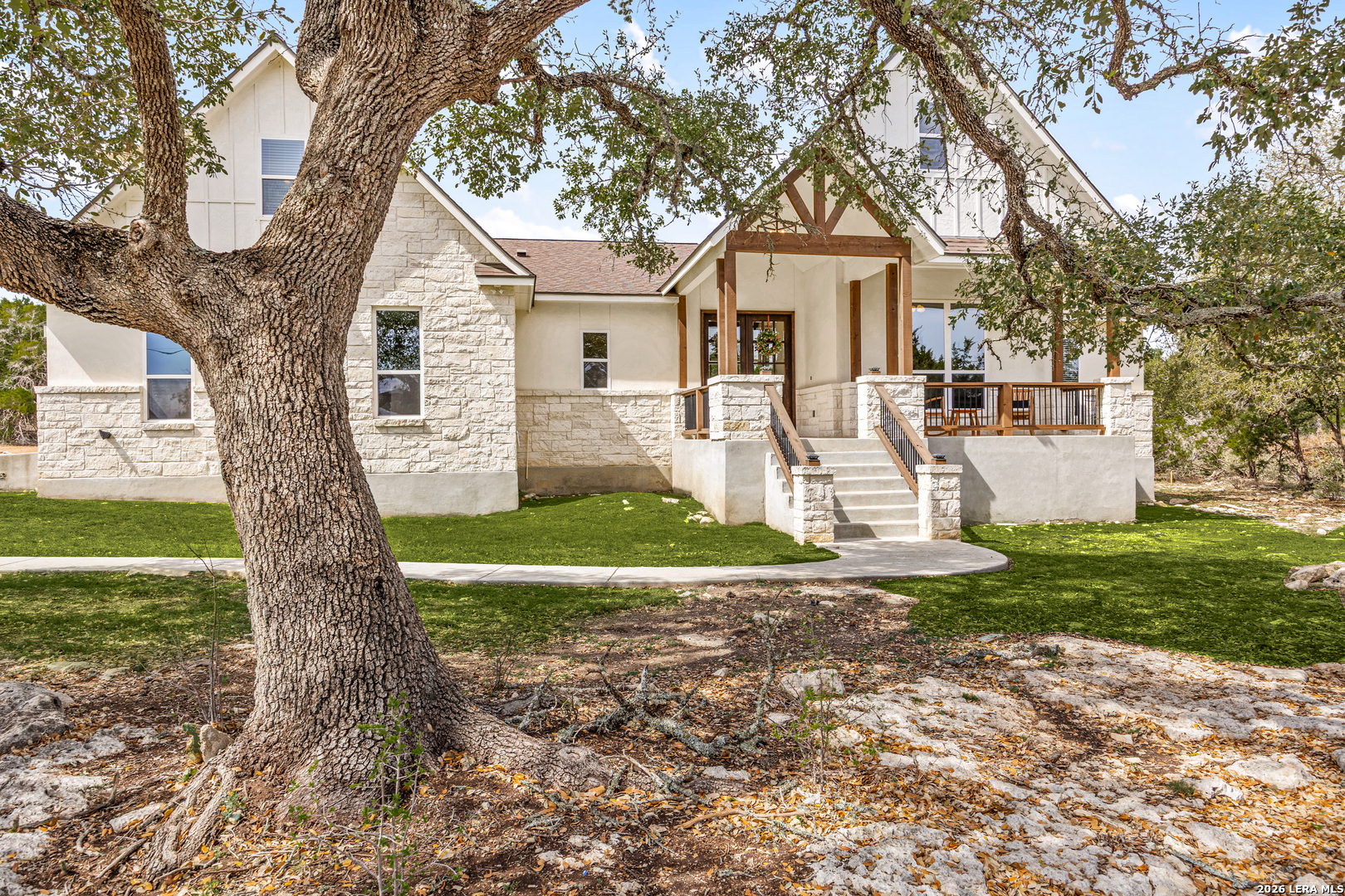 a front view of a house with a yard and trees